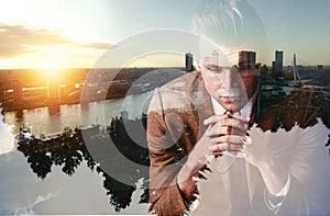 Keeping a watchful eye on his empire. a focused young businessman superimposed over a cityscape.