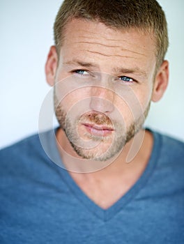 He keeps his style simple. Studio shot of a handsome young man posing against a white background.