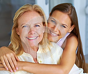 She keeps me young. a grandchild hugging her grandmother from behind.