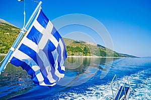 Kefalonia island coast waving Greek flag on boat Ionian Sea Greece