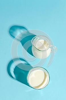 Kefir in a glass beaker on a blue background with copy space