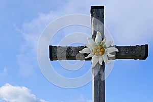 Summit cross with the Edelweiss flower on top of the Kehlstein Obersalzberg close to Berchtesgaden in Bavaria photo