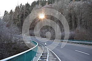 Kehrig, Germany - 12 21 2021: dark serpentine out of Elztal in winter with sun between trees