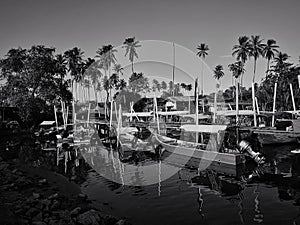 Kelantan, Malaysia -fishing boat near wooden jetty. Beautiful malaysian landscape. Sunset reflection in the water.