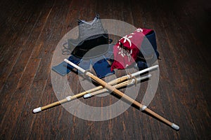 Kendo gloves, helmet and bamboo sword on a wooden surface