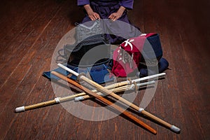 Kendo gloves, helmet and bamboo sword on a wooden surface