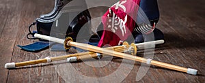 Kendo gloves, helmet and bamboo sword on a wooden surface