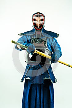Kendo - Kendoka in full armor with shinai, studio shot on white background.