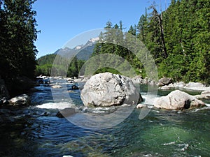 Kennedy River with rocks, trees, and mountains on Vancouver Island, BC, Canada