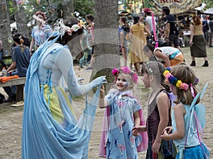 A beautiful girl dressed as a fairy play with children at the annual Bristol Renaissance Faire