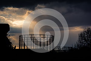 Kensal Green gasometer silhouetted in front of angry sky photo