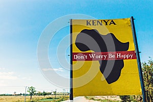 Kenya for the people signpost in yellow colors and blue sky by the side of the road in Africa. Freedom, people, quote, future, pre