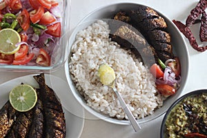 Kerala meals with red rice, sardines curry, sardine fry and coconut based green gram curry photo