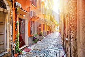 Kerkyra city narrow street view with yellow colorful houses during sunny day. Corfu Island, Ionian Sea, Greece