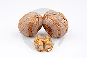 Two walnuts and walnuts with organic shell on a white background