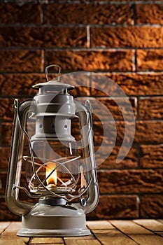 Kerosene lamp on brick background