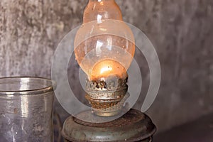 Kerosene lamp burning on a gray wall background