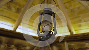 Kerosene old lamp hanging on a wooden ceiling background