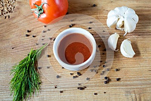 Ketchup in a bowl, fresh tomato, dill sprig and whole tomato close-up