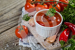 Ketchup and ingredients on wood background