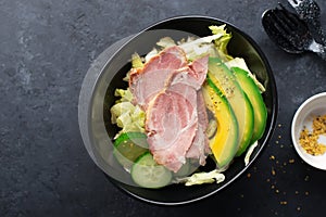 Keto bowl. Lots of lettuce, green vegetables, avocados, olive oil and juicy baked meat. For a ketogenic diet, lunch box