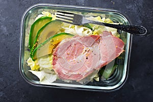 Keto bowl. Lots of lettuce, green vegetables, avocados, olive oil and juicy baked meat. For a ketogenic diet, lunch box