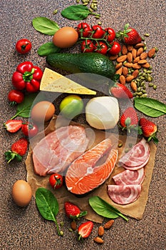 Keto diet concept.Healthy foods low in carbohydrates. Salmon, chicken, vegetables, strawberries, nuts, eggs and tomatoes, cutting