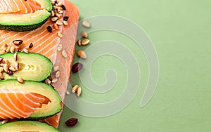 Keto diet concept. salmon, avocado, nuts and seeds, pastel green background, top view. Keto diet food ingredients. Generative AI