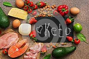 Keto diet food. Healthy low carbs products.Keto diet concept. Vegetables, fish, meat, nuts, seeds, strawberries, cheese on a brown