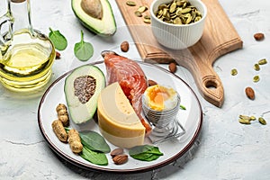 Keto diet food, salmon, avocado, cheese, egg, spinach and nuts. Ketogenic low carbs diet concept. Ingredients for healthy foods