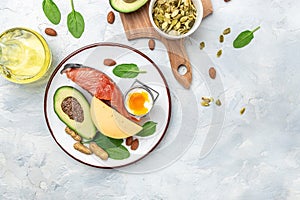 Keto diet food, salmon, avocado, cheese, egg, spinach and nuts. Ketogenic low carbs diet concept. Ingredients for healthy foods