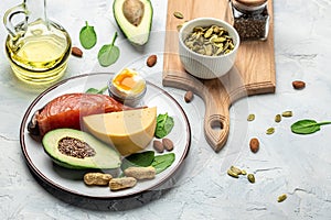 Keto diet food, salmon, avocado, cheese, egg, spinach and nuts. Ketogenic low carbs diet concept. Ingredients for healthy foods.