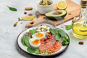 Keto diet food, salmon, avocado, cheese, egg, spinach and nuts. Ketogenic low carbs diet concept. Ingredients for healthy foods