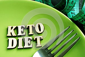 Keto diet on a green plate and measuring tape