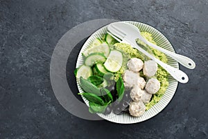 Keto paleo diet lunch, mashed broccoli with butter, meat balls in sour cream sauce, spinach, cucumber, olives. Low