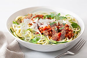 Keto paleo zoodles bolognese: zucchini noodles with meat sauce and parmesan