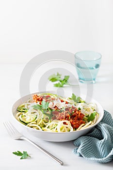 Keto paleo zoodles bolognese: zucchini noodles with meat sauce and parmesan