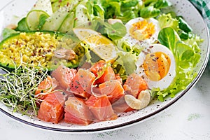 Ketogenic diet breakfast. Salt salmon salad with greens, cucumbers, eggs and avocado.