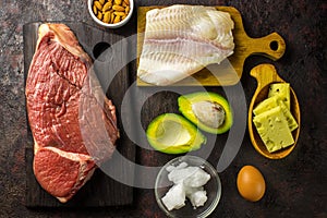 Ketogenic diet food. Balanced low-carb food background. Fish, meat, cheese, nuts on a dark background. Healthy balanced food with