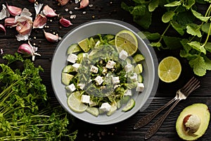 Ketogenic diet green salad with cucumbers, avocado, feta cheese and lime dressing