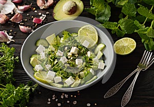 Ketogenic diet green salad with cucumbers, avocado, feta cheese and lime dressing