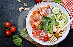 Ketogenic diet salad bowl with salmon, shrimp, avocado, spinach, cucumber, tomato, cashew nuts, sesame. Low-carbohydrate breakfast