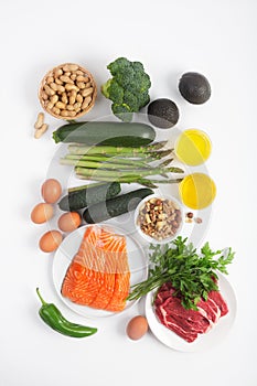 Ketogenic, keto diet, including vegetables, meat and fish, nuts and oil on white background