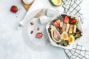 Ketogenic low carbs diet, Plate with keto foods: two eggs, avocado, grilled chicken fillet, nuts, strawberries and fresh