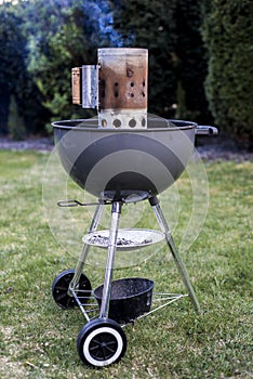 Kettle barbecue charcoal grill roasting BBQ standing on gras ready for action