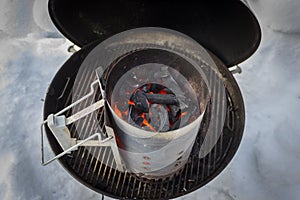 A kettle barbeque with a lighting chimney
