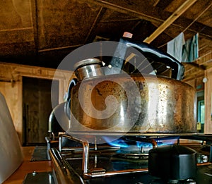 A kettle boiling water on a gas hob. Now we\'re cooking with gas photo