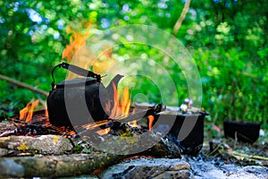 Kettle on campfire. Camping or hiking. Background with selective focus