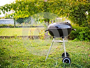 Kettle Charcoal BBQ Barbecue Grill in garden or backyard.