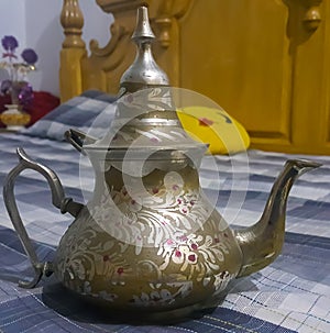 Kettle of gold colour with decoration photo